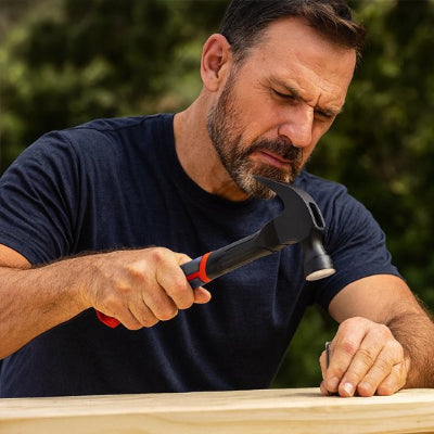 marteau homme met une pointe sur une planche