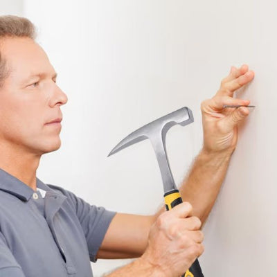 marteau homme pointe clou dans mur